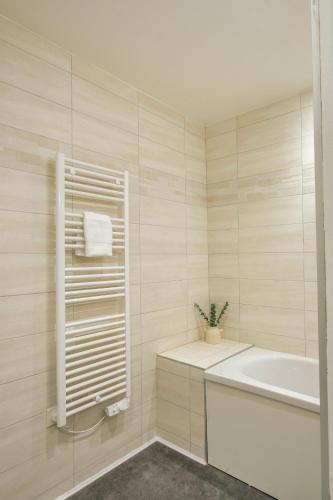 une salle de bain blanche avec une baignoire et un lavabo dans l'établissement Sainte-Anne, à Reims