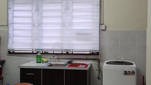 eine kleine Küche mit einem Waschbecken und einem Fenster in der Unterkunft Ct HOMESTAY in Changlun