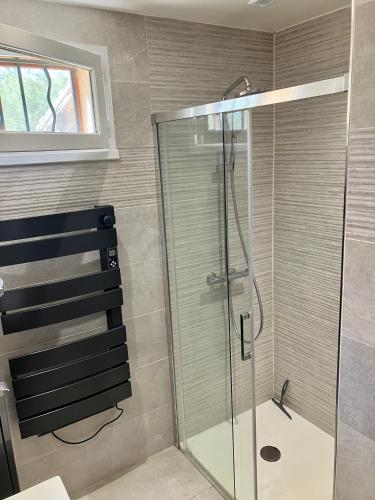 une douche avec une porte vitrée dans une salle de bain dans l'établissement Villa T3, à Nans-les-Pins