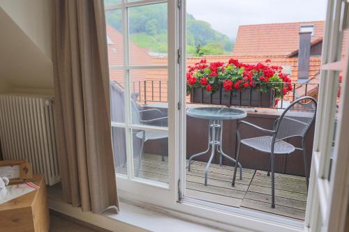 a balcony with a table and chairs and a window at Hotel-Gasthaus Goldener Engel in Glottertal