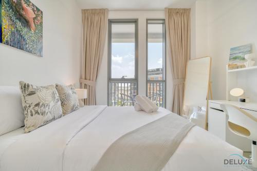 Un dormitorio con una gran cama blanca y una ventana en Serene 1BR at Afnan 3 Midtown Dubai Production City by Deluxe Holiday Homes en Dubái