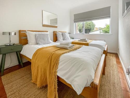 two twin beds in a bedroom with a window at Seaways in Lee-on-the-Solent
