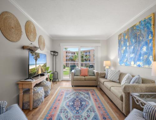 a living room with a couch and a tv at Beach Tennis 217 in Coquina Gables