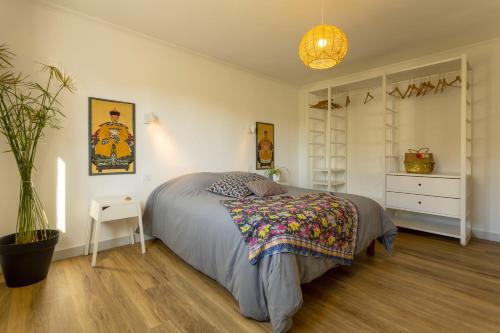 um quarto com uma cama e um vaso de plantas em Maison Névez Campagne Calme Piscine em Clohars-Fouesnant