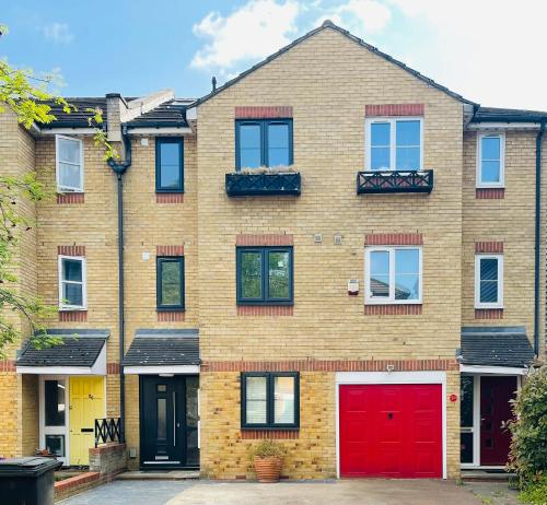 a brick house with red doors and windows at Riverside Double Room Garden View E14 in London
