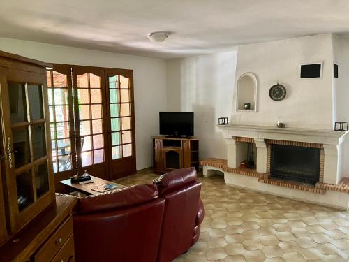 un salon avec un canapé et une cheminée dans l'établissement Villa T3, à Nans-les-Pins