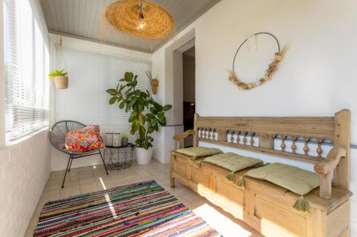 - un salon avec un banc et un tapis dans l'établissement Maison Coz Campagne Calme Piscine, à Clohars-Fouesnant