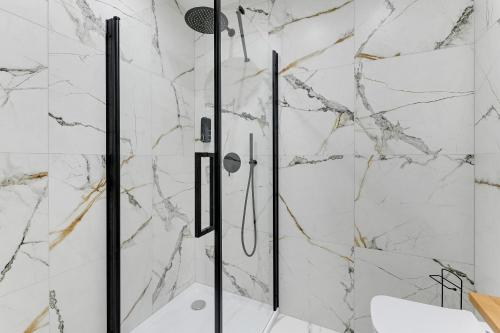 a bathroom with a shower with marble walls at T8- Willa Tetmajera Gdynia in Gdynia