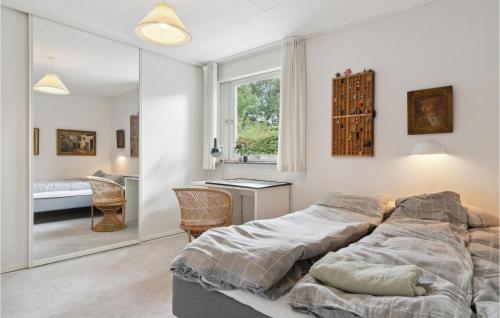 een slaapkamer met een bed, een bureau en een spiegel bij Amazing Home In Dronningmlle With Wifi in Dronningmølle