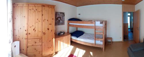 a room with two bunk beds and a wooden cabinet at Feriendorf Reichenbach - Wieselweg 3 in Nesselwang