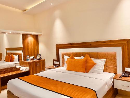 pokój hotelowy z 2 łóżkami i pomarańczowymi poduszkami w obiekcie Stay @Northview park hotel zirakpur w mieście Zirakpur