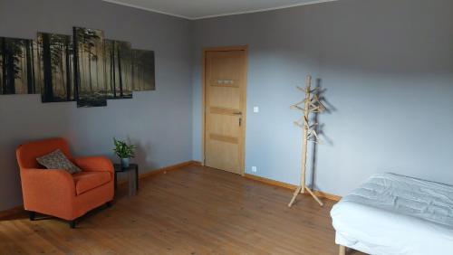 a bedroom with an orange chair and a bed at Grange De Sagne maison et table d hôtes avec dîner sur réservation in Saint-Jean-Roure