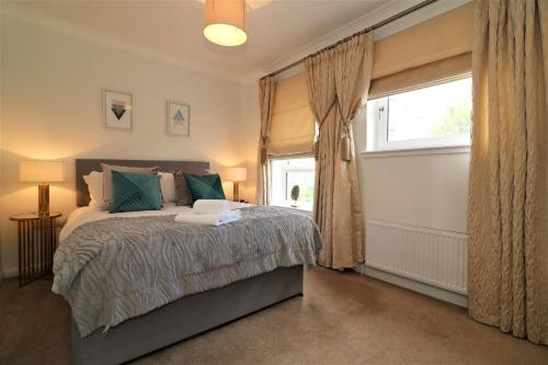 a bedroom with a large bed and a window at Signature - Macneish House East Kilbride in East Kilbride