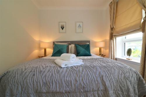 a bedroom with a bed with towels on it at Signature - Macneish House East Kilbride in East Kilbride