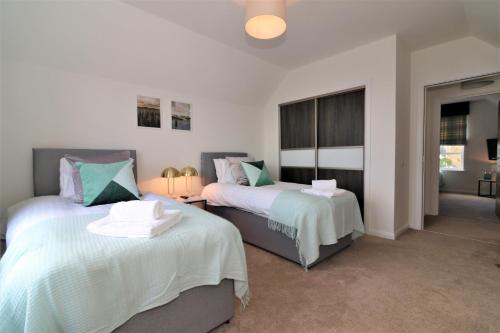a bedroom with two beds with white and blue at Signature - Macneish House East Kilbride in East Kilbride