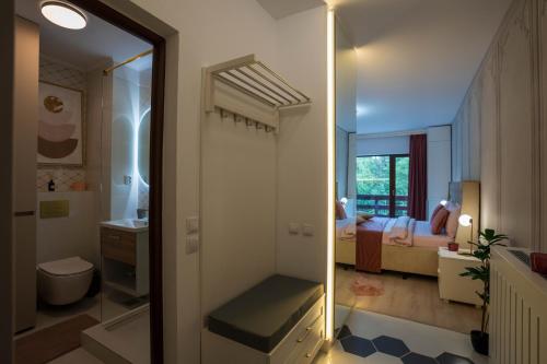 a bathroom with a walk in shower and a bedroom at Love Luxury studio in Predeal