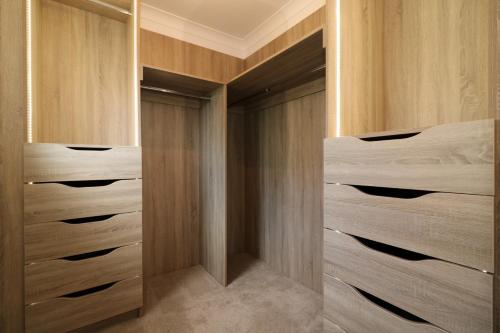 a walk in closet with wooden cabinets and drawers at Signature - Macneish House East Kilbride in East Kilbride