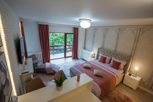 a bedroom with a large bed and a balcony at Love Luxury studio in Predeal