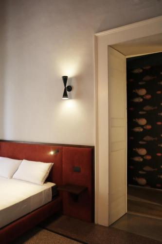 a bedroom with a bed and a light on the wall at Roiss Haus Suites in Lecce