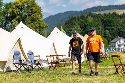 two men walking in front of a group of tents at RacingTours RaceCamp - Spielberg in Spielberg