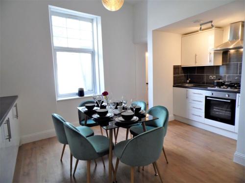 - une cuisine et une salle à manger avec une table et des chaises dans l'établissement Signature - Langlands House, à Glasgow