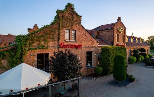 a large brick building with a clock on it at Pensjonat Retro in Łomża