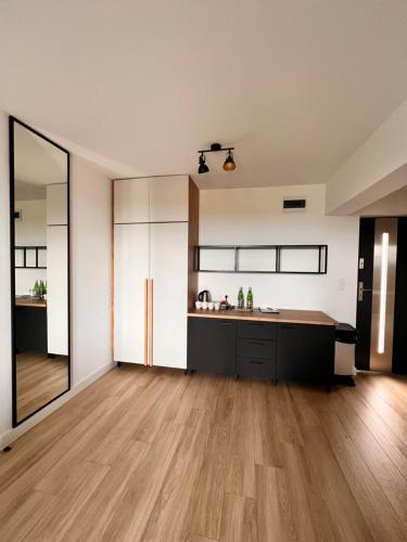 an open kitchen with wooden floors and white walls at Columbus Rowy in Rowy