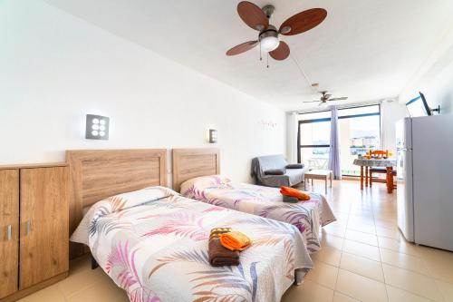 a bedroom with two beds and a refrigerator at Estudio en la playa in Roquetas de Mar
