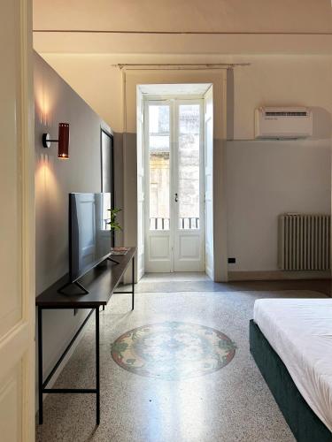 a bedroom with a bed and a desk with a television at Roiss Haus Suites in Lecce