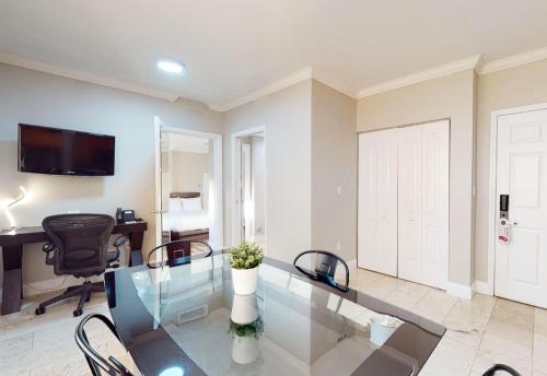 a living room with a glass table and a desk at Nuvo Suites Hotel - Miami Doral in Miami