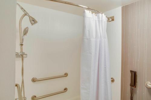 a shower with a white shower curtain in a bathroom at Courtyard by Marriott Ocala in Ocala