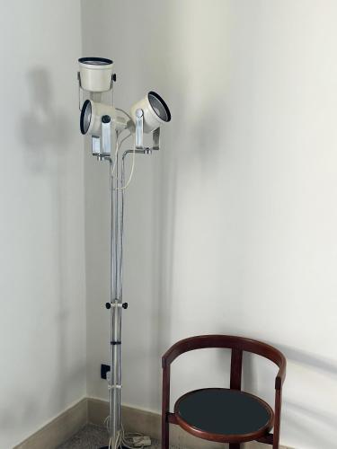 a chair and a floor lamp in a room at Roiss Haus Suites in Lecce