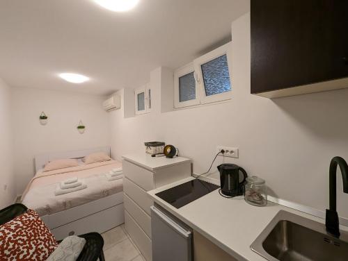a small kitchen with a sink and a bed at Petite Studio With Ensuite Bathroom in Zagreb