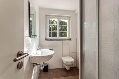 a bathroom with a sink and a toilet and a window at alter Speicher in Warendorf