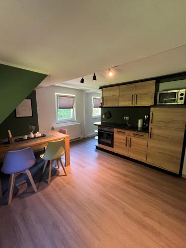 a large kitchen with a wooden table and chairs at Maisonette für 6P mit toller Aussicht in Hohleborn