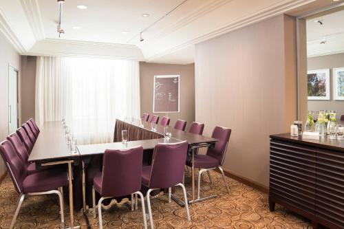 a conference room with a table and purple chairs at Sheraton Bratislava Hotel in Bratislava