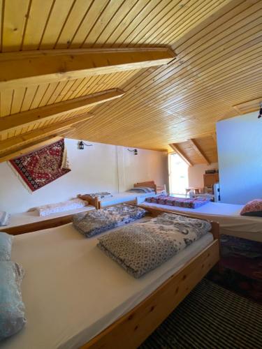 two beds in a room with wooden ceilings at Etno-house Lukomir in Lukomir