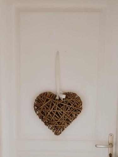 a heart shaped light fixture hanging from a white wall at Duplex de L'Artisterie in Mondonville