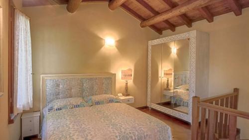 a bedroom with a bed and a large mirror at La casetta nel bosco in Mantova