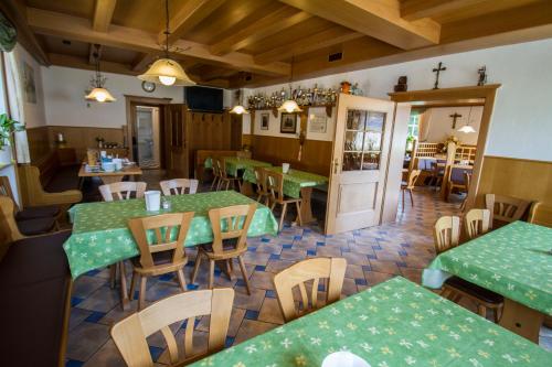 ein Restaurant mit grünen Tischen und Holzstühlen in der Unterkunft Gasthof zur Länd in Moosburg