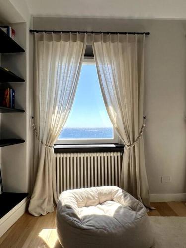 um quarto com uma janela com uma cama em frente em La Perla di Boccadasse em Gênova