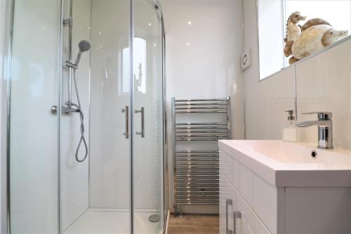 a white bathroom with a shower and a sink at Signature - Gordon House in Glasgow