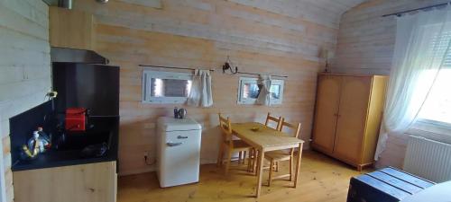 una pequeña cocina con mesa y nevera en Duplex de L'Artisterie, en Mondonville