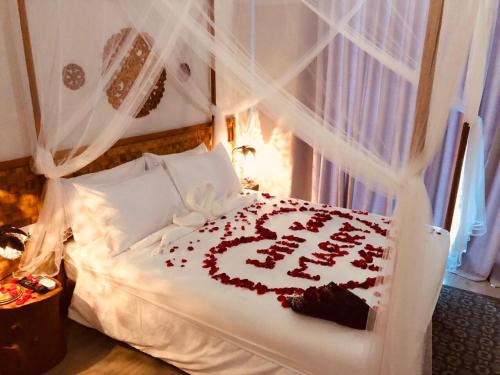 a bed with a sign that says happy anniversary at Sandy Heaven Maldives in Gulhi