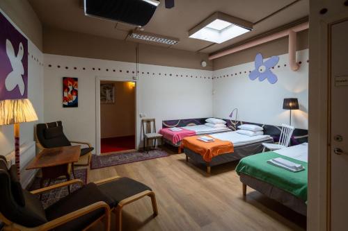 ストックホルムにあるReimersholme Hotelのベッド2台、ソファ、テレビが備わる客室です。