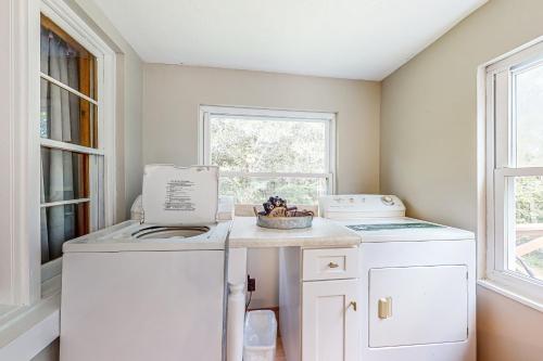 eine Waschküche mit einer Waschmaschine, einem Trockner und einem Fenster in der Unterkunft Bear Crossing in New Tazewell