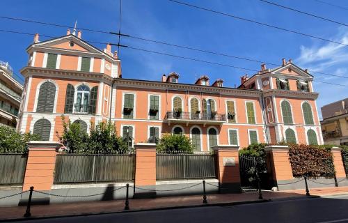 een groot gebouw van rode baksteen in een stadsstraat bij Villa Eugenia - Luxury Flat with Parking Space in Bordighera