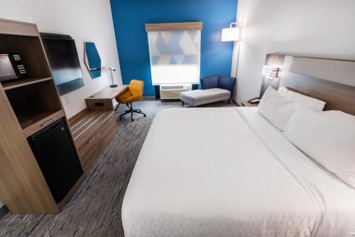 a hotel room with a large bed and a desk at Holiday Inn Express & Suites - Huntsville Airport, an IHG Hotel in Madison