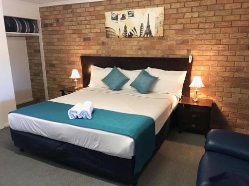 Una habitación de hotel con una cama con una toalla. en KippaRing Village Motel (Near Redcliffe) en Redcliffe