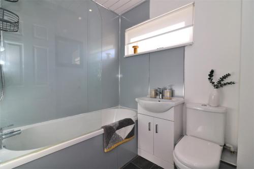 a bathroom with a toilet and a tub and a sink at Signature - Honeywell House in Chapelhall